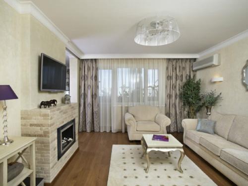 Телевизор над угловым камином. Дизайн интерьера гостиной с камином