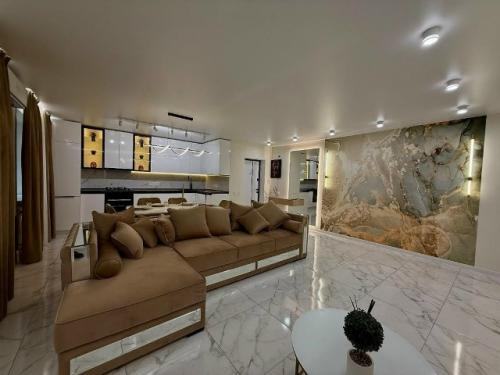 Просторная кухня - гостиная выполнена в современном стиле с акцентом на комфорт и элегантность. 01