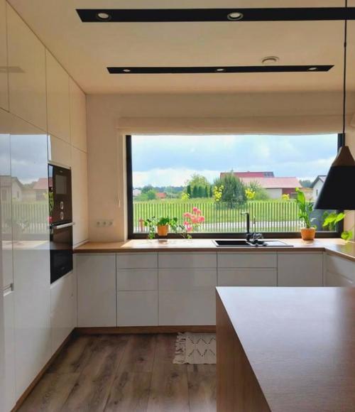 Просторная светлая кухня с большим окном и стильными аксессуарами. 01