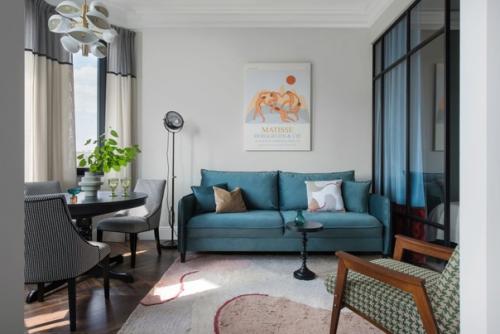 Стильная студия с зеленой кухней и спальней за перегородкой.