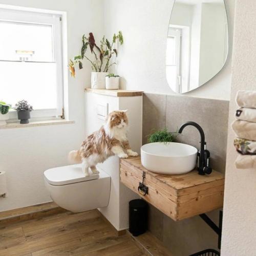 Хороший спокойный интерьер: зелёная печь и тёплые акценты, белые стены, деревянная отделка и обилие зеленых растений. 03